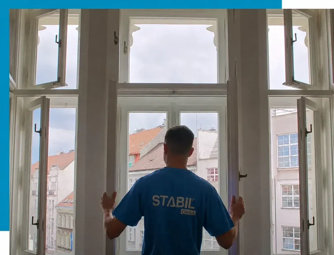 Muž kontroluje otevřená dřevěná špaletová okna