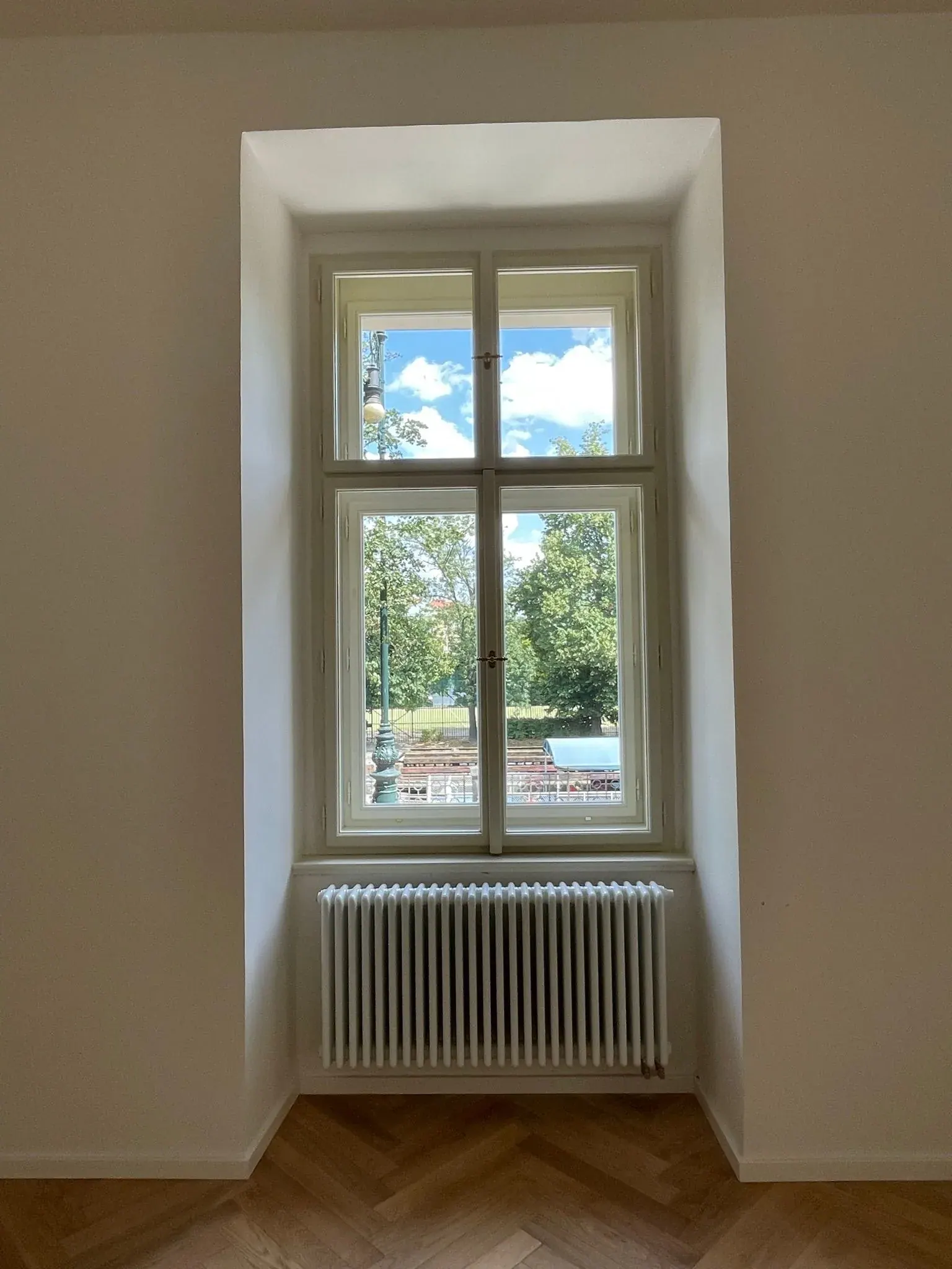 Bílá špaletová okna ve výklenku nad radiátorem