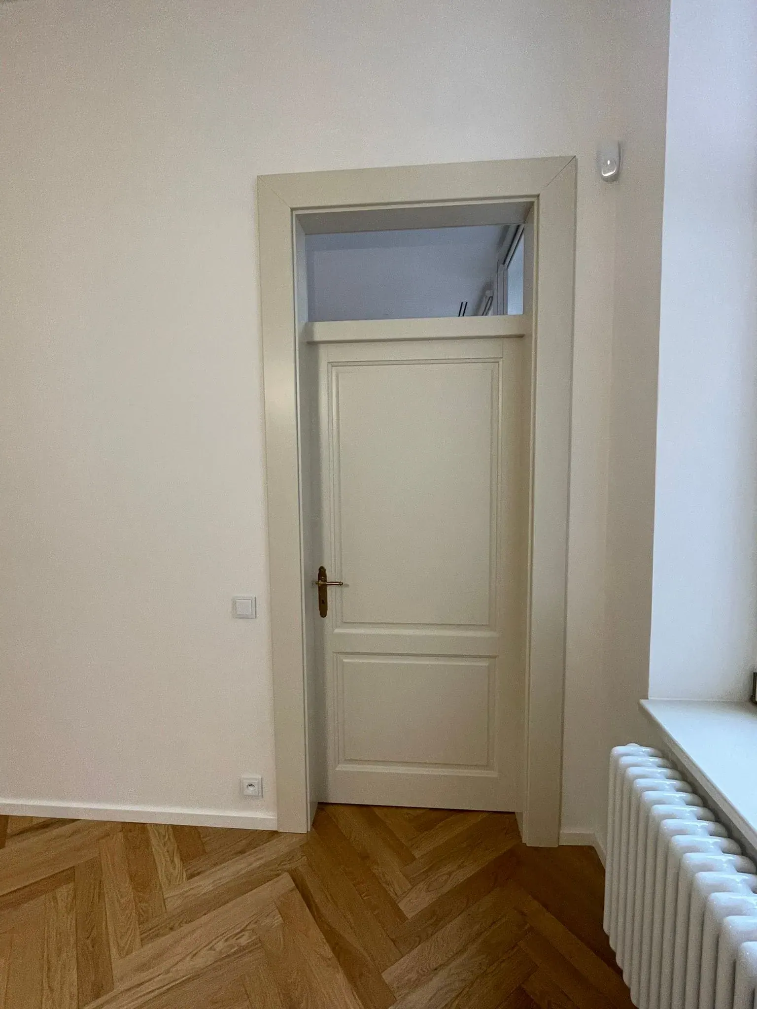 Bílé interiérové dveře s nadsvětlíkem v bytě