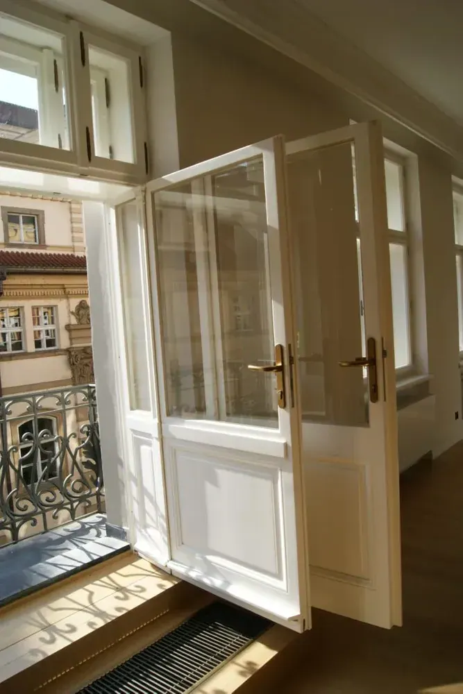 Otevřené špaletové dveře s prosklenou výplní vedoucí na balkon