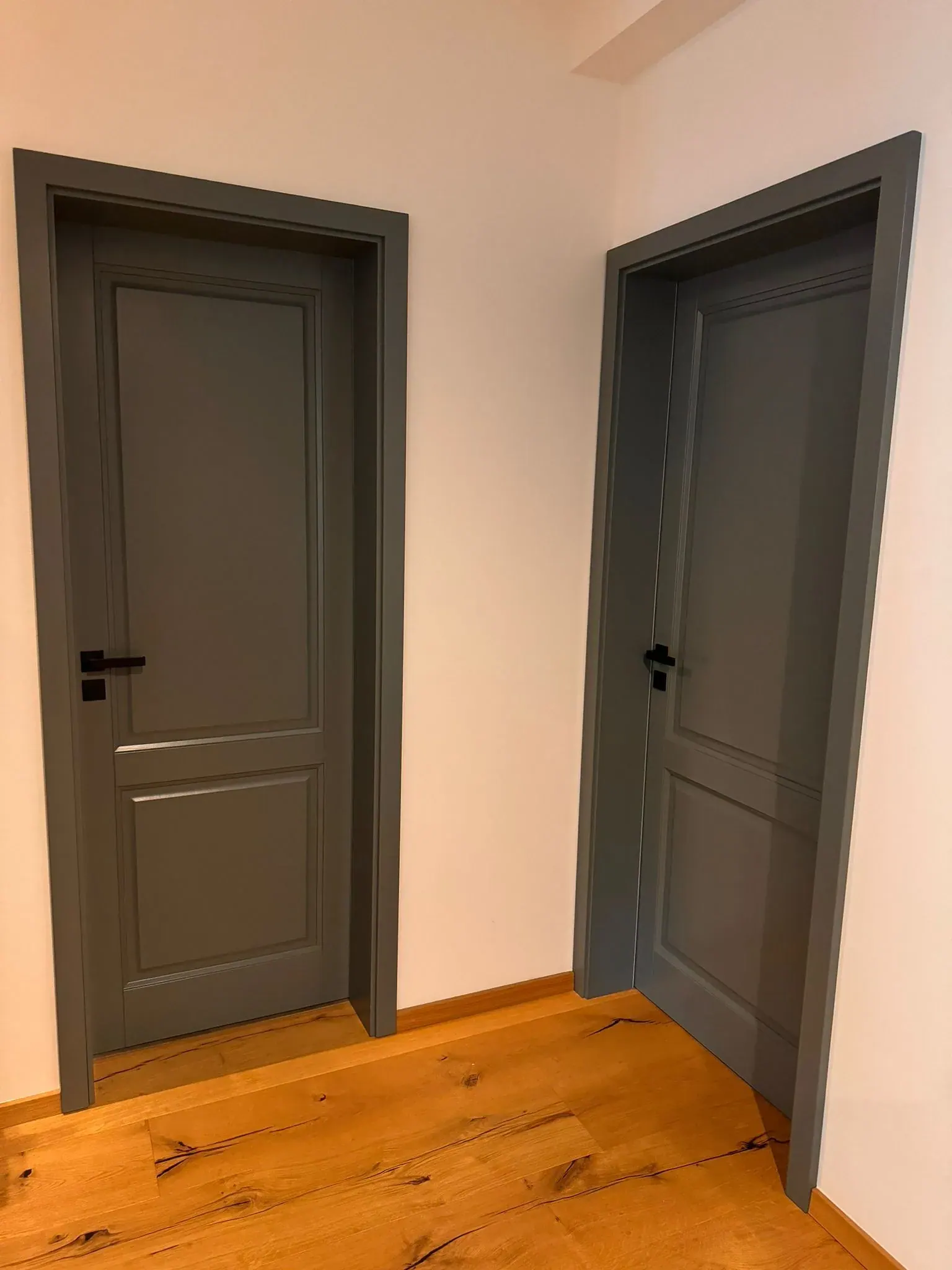 Šedé interiérové dveře s černými klikami