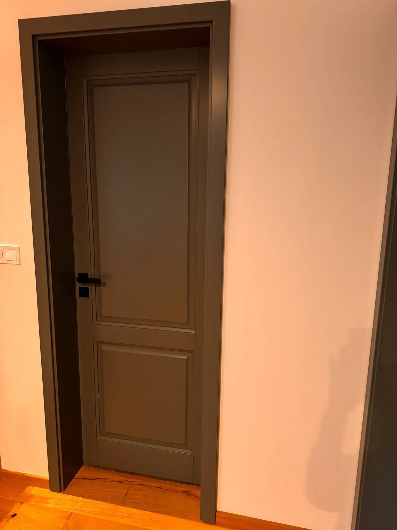 Tmavě šedé dřevěné interiérové dveře s černým kováním