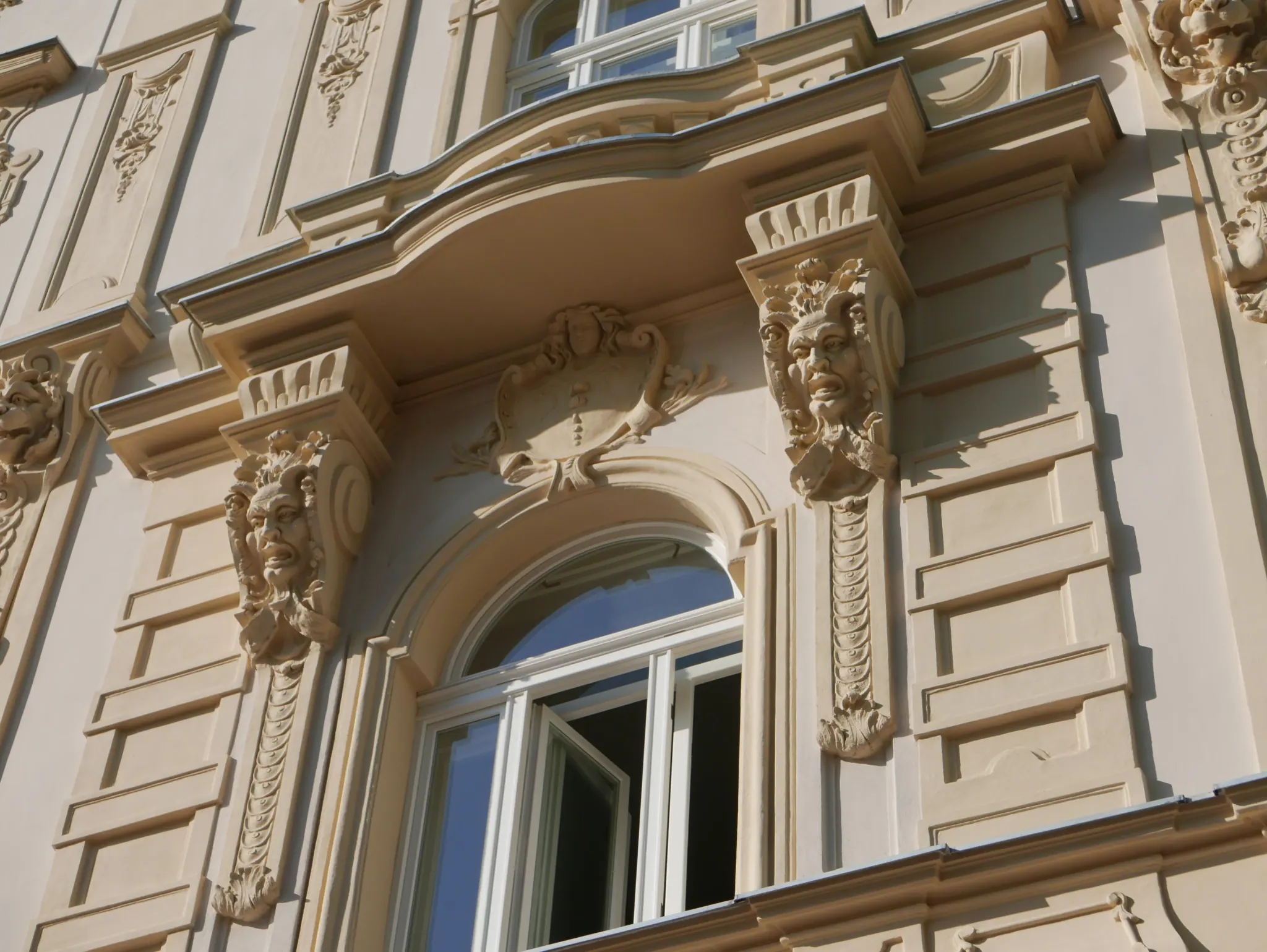 Okno s maskaronem - detail zdobení - Šmeralova 1, Praha 7