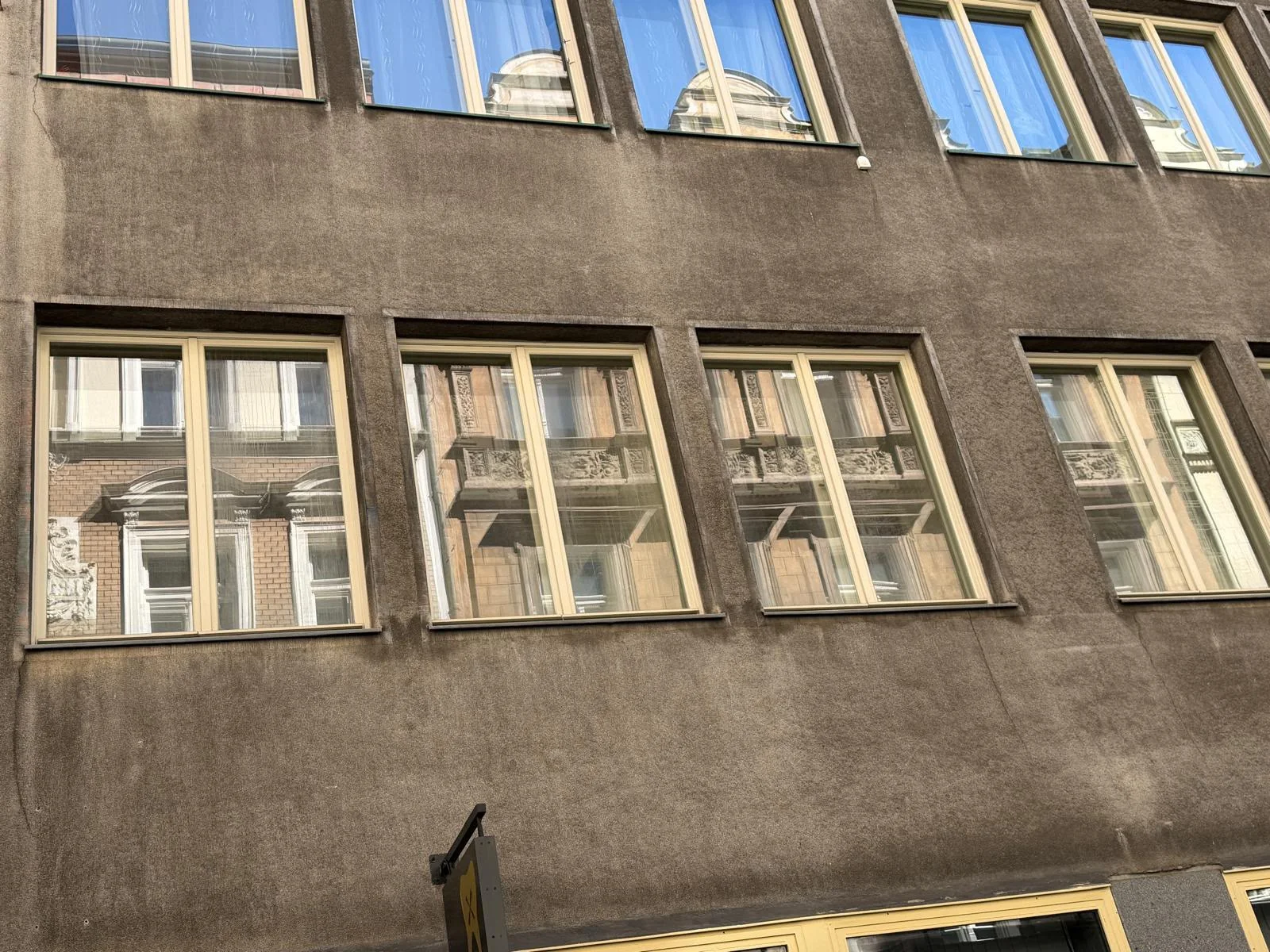 Světlá dvoukřídlá okna s odrazem protějšího domu, Benediktská 688/6, Praha 1.