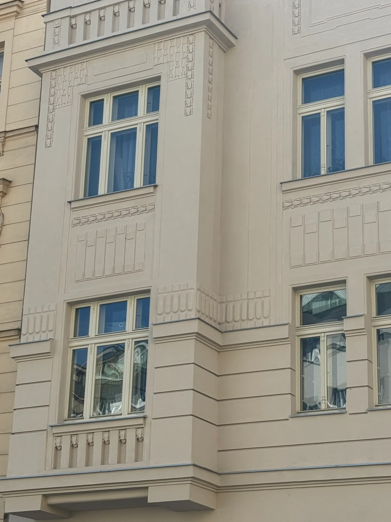 Detail oken a zdobené fasády arkýře, Haškova 16, Praha 7.