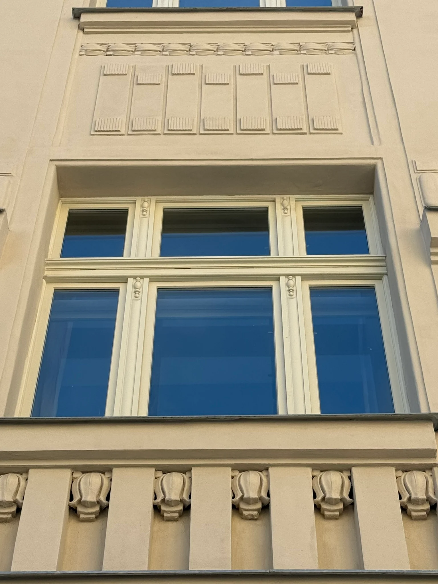 Detail zdobeného špaletového okna s nadsvětlíkem, Haškova 16, Praha 7.
