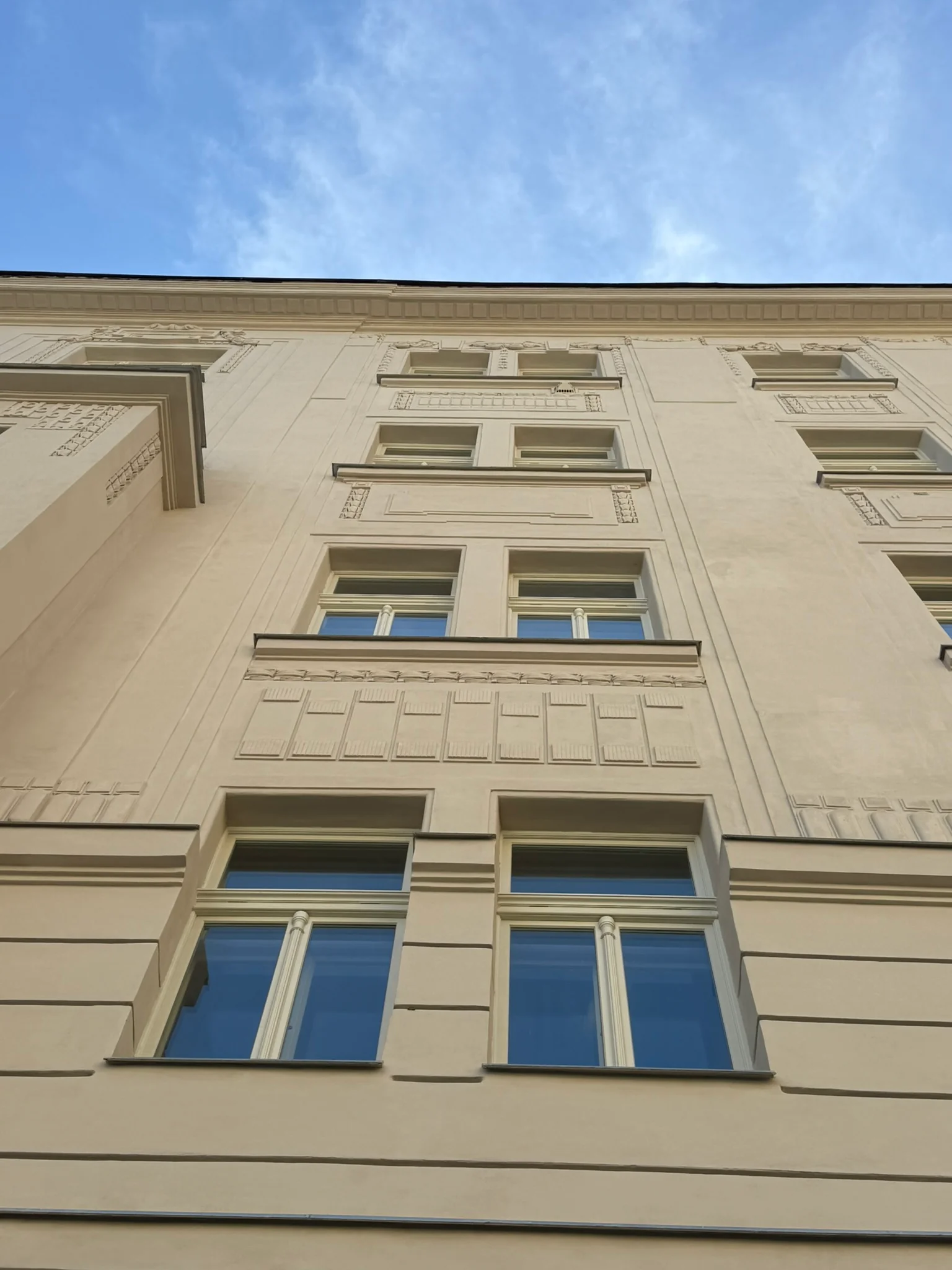 Dvojice špaletových oken v jednotlivých podlažích domu Haškova 16, Praha 7.