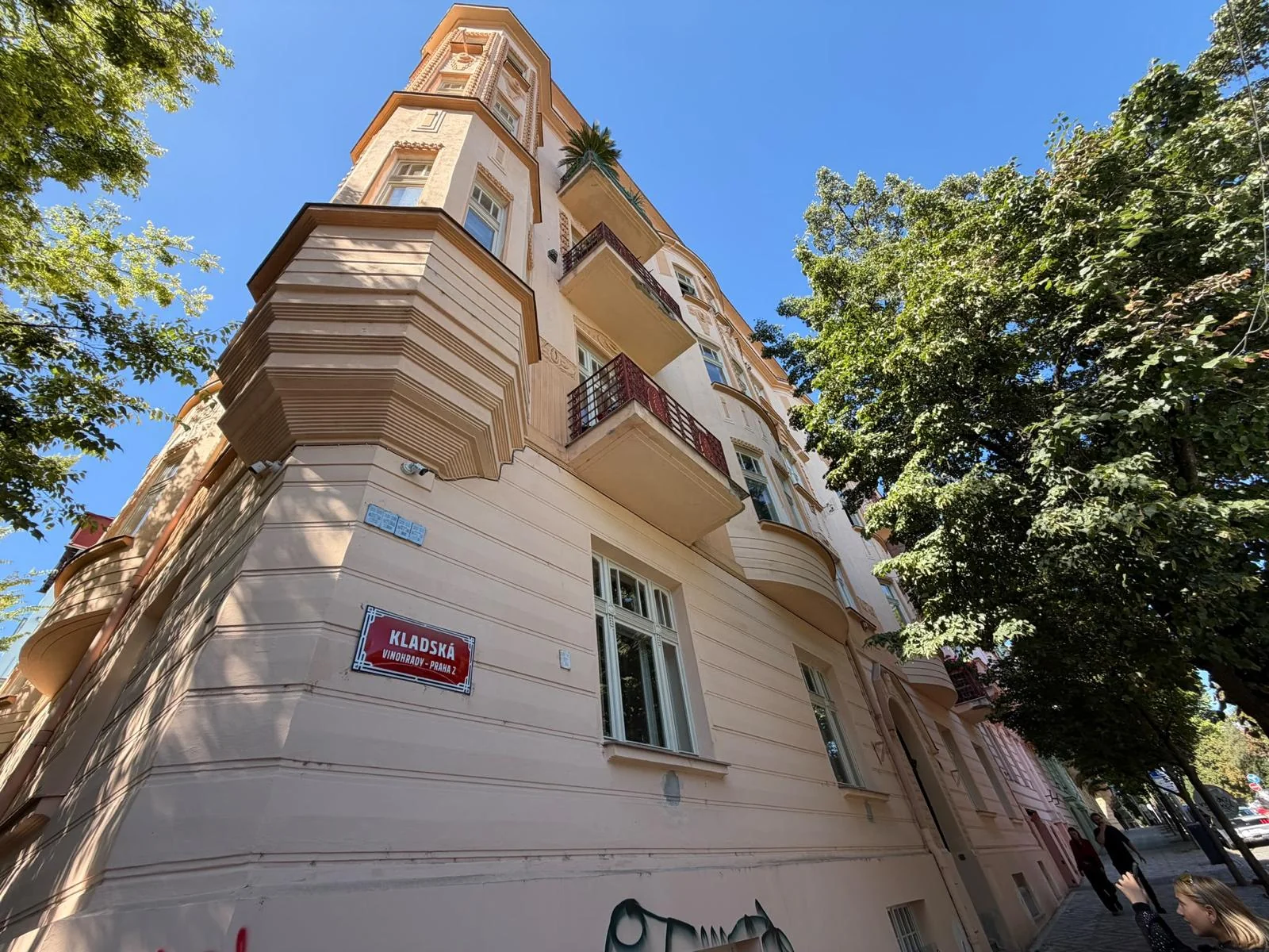 Světlá špaletová okna v nároží domu Kladská 1462/3 v Praze 2, s uliční cedulí a balkonem.