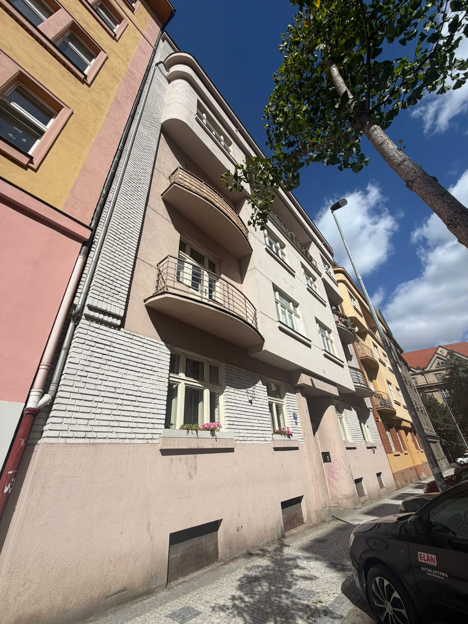 Šikmý pohled na špaletová okna a zaoblené balkony domu Kyjevská 779/9 v Praze 6.