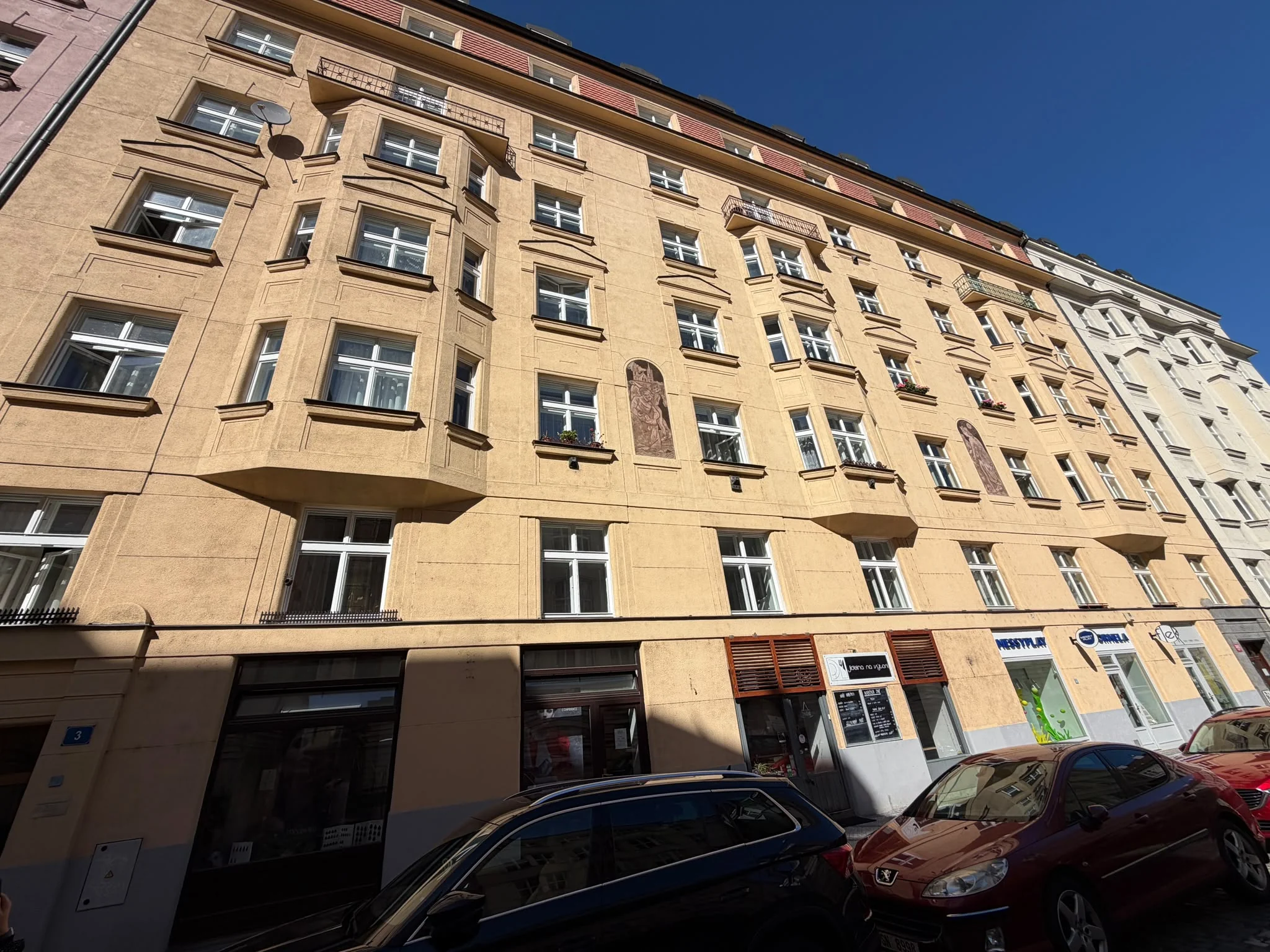 Celé uliční průčelí domu Ladova 2044/3 v Praze 2 se špaletovými okny a arkýři.